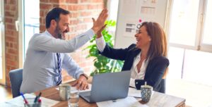 Team Member High Fiving in front of a Laptop