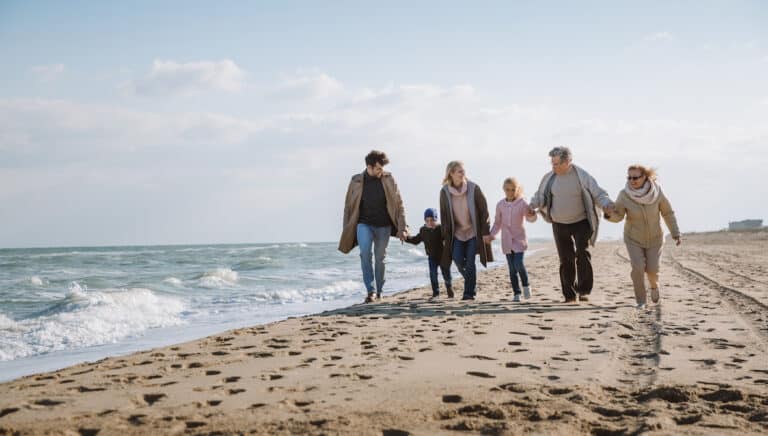 Multigenerational family walking on the beach